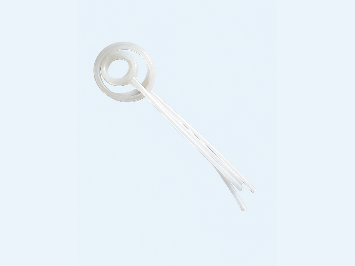 Translucent circular seal loops with attached clear tubing on a pale background — Non-Implant Andrology Device Inflatable Seal