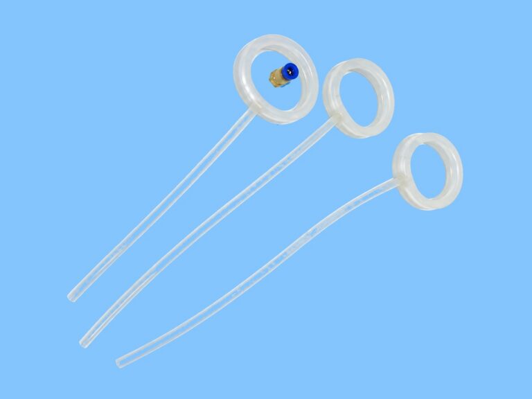 Three translucent circular seal rings with attached clear tubes on a blue background — Non-Implant Andrology Device Inflatable Seal