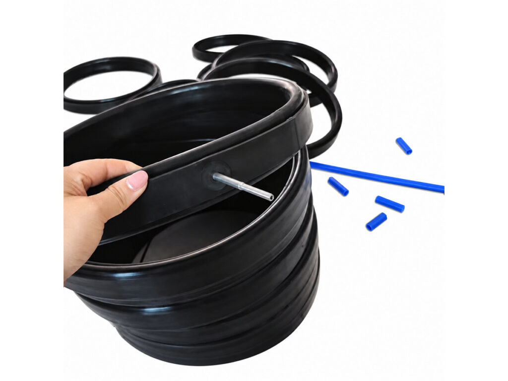 Stack of black circular seals with metal fitting and blue tubes — Industrial Lift Inflatable Seal Heavy Weight Loading